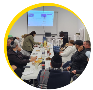 תמונה של ישיבה עם הרבה אנשים בחדר ישיבות